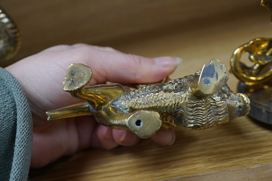 Three brass radiator mascots; one of a coiled snake, one of a dragon, and a winged lion, tallest 18cm. Condition - fair to good.